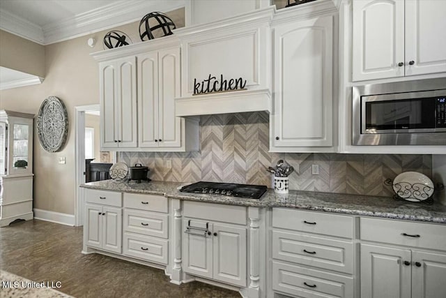 kitchen featuring white cabinetry, ornamental molding, stainless steel appliances, and backsplash