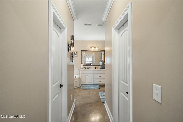 hall featuring dark tile patterned floors, visible vents, and ornamental molding