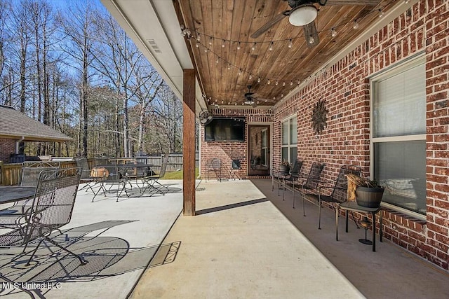 view of patio featuring a ceiling fan, outdoor dining space, and fence