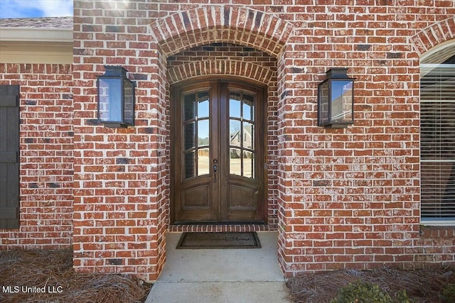 view of exterior entry with french doors and brick siding