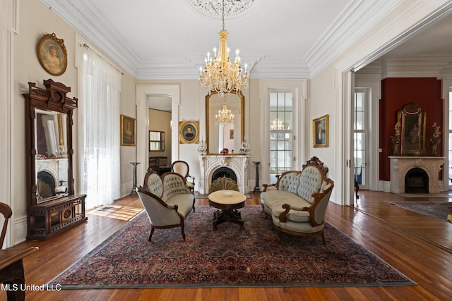 sitting room featuring a chandelier, a fireplace, hardwood / wood-style flooring, and crown molding