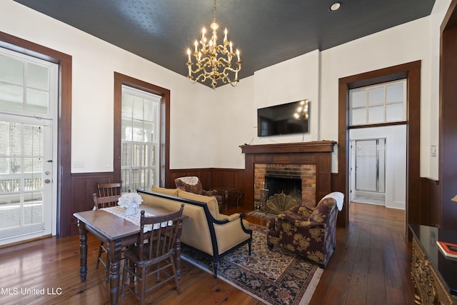 living area featuring wainscoting, a fireplace, and a healthy amount of sunlight