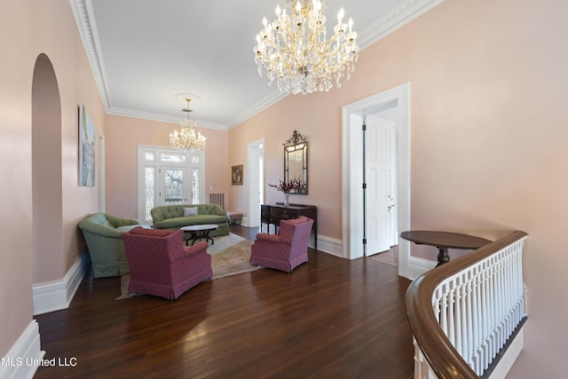 living area with crown molding, a chandelier, arched walkways, and dark wood-type flooring