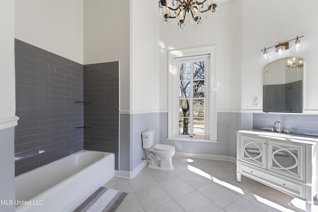 full bath featuring a chandelier, a bathing tub, toilet, vanity, and tile patterned floors