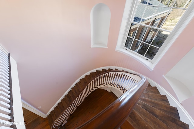 stairway with baseboards and wood finished floors