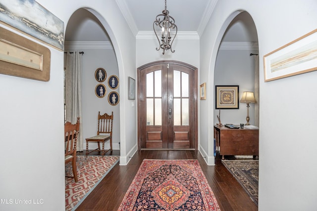 foyer featuring hardwood / wood-style floors, crown molding, french doors, and arched walkways