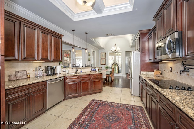 kitchen featuring light tile patterned floors, appliances with stainless steel finishes, crown molding, and a sink