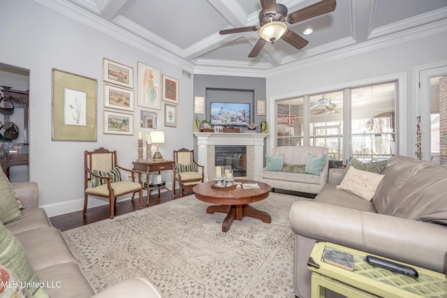 living room with crown molding, baseboards, wood finished floors, a glass covered fireplace, and coffered ceiling