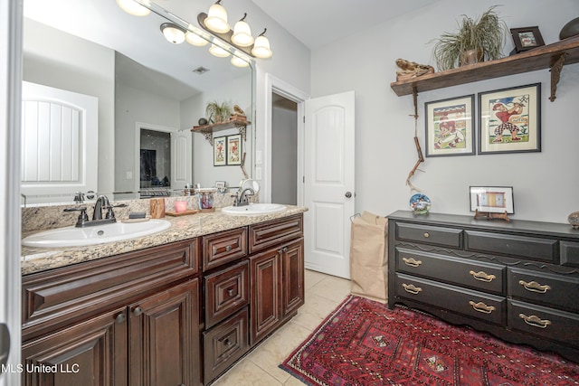 bathroom featuring a sink, visible vents, double vanity, and tile patterned floors