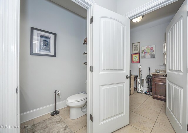 bathroom with tile patterned flooring, toilet, and baseboards