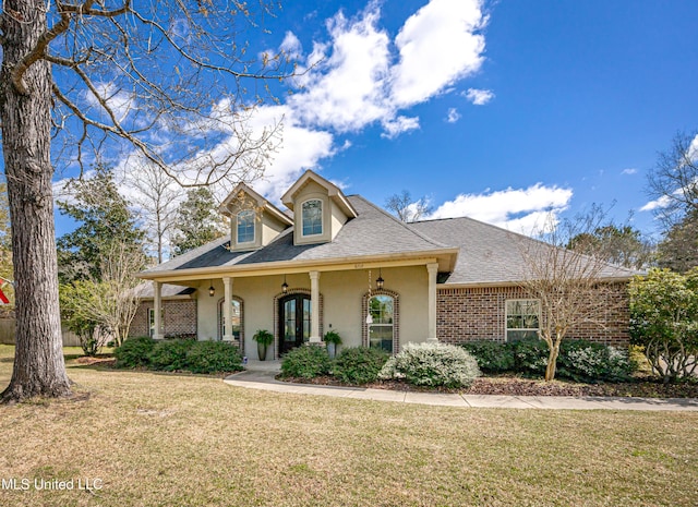 view of front of house featuring brick siding, roof with shingles, and a front yard