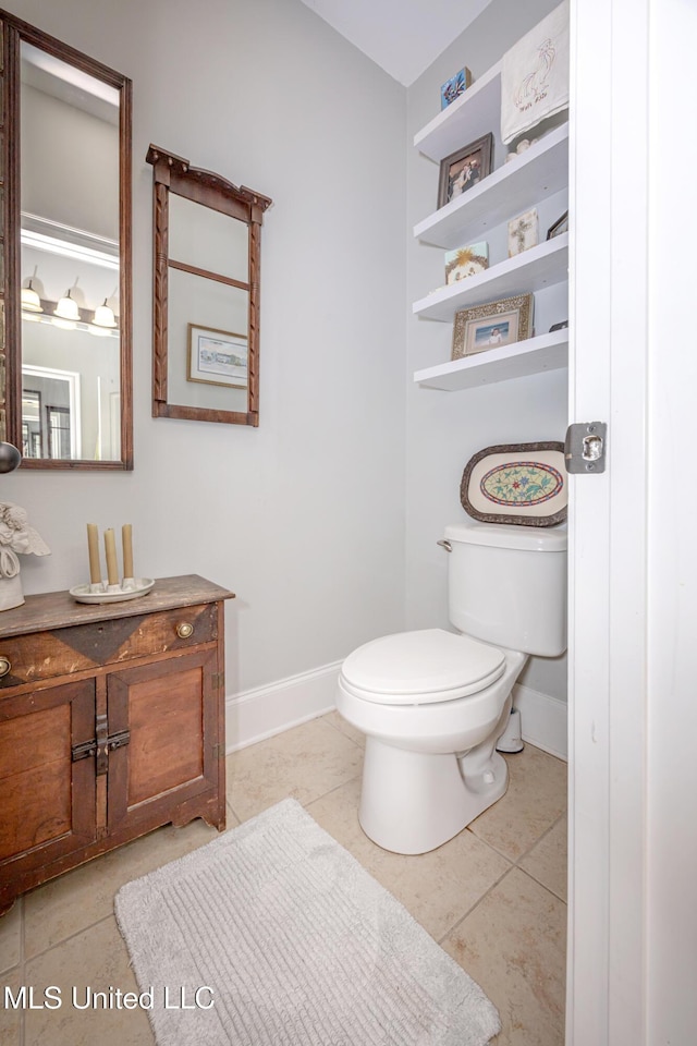 bathroom featuring tile patterned floors, toilet, vanity, and baseboards