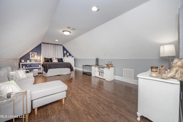 bedroom featuring visible vents, baseboards, lofted ceiling, and wood finished floors