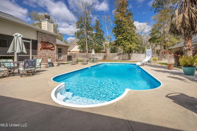 view of pool with a patio, a water slide, and a fenced backyard