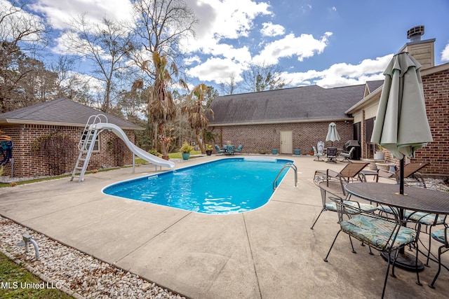 outdoor pool featuring a patio and a water slide