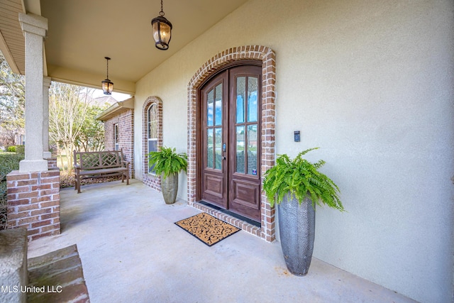 property entrance featuring french doors and stucco siding