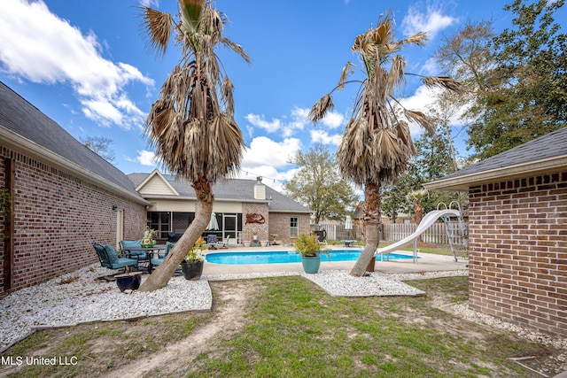 view of pool featuring a fenced in pool, a patio, a water slide, and fence