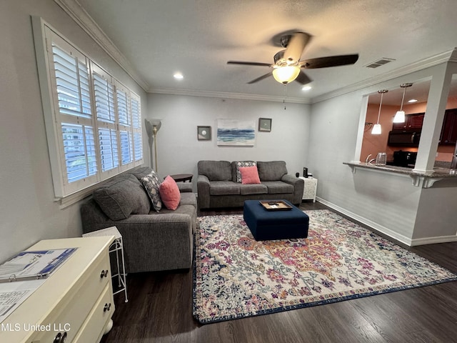 living room with dark hardwood / wood-style floors, ceiling fan, and crown molding