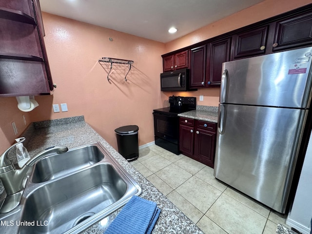 kitchen with black appliances, light tile patterned flooring, and sink