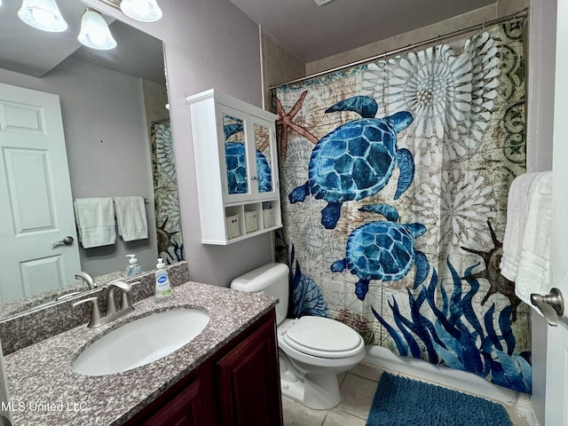 bathroom with tile patterned flooring, vanity, and toilet