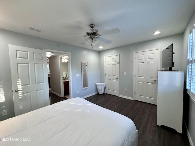 bedroom featuring ceiling fan, dark hardwood / wood-style flooring, electric panel, and ensuite bath