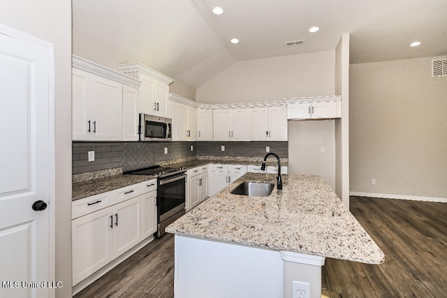 kitchen featuring dark hardwood / wood-style flooring, stainless steel appliances, sink, lofted ceiling, and an island with sink