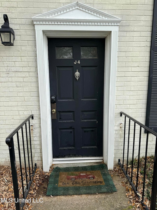 property entrance featuring brick siding