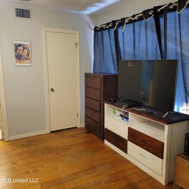 unfurnished bedroom with visible vents, baseboards, and wood finished floors