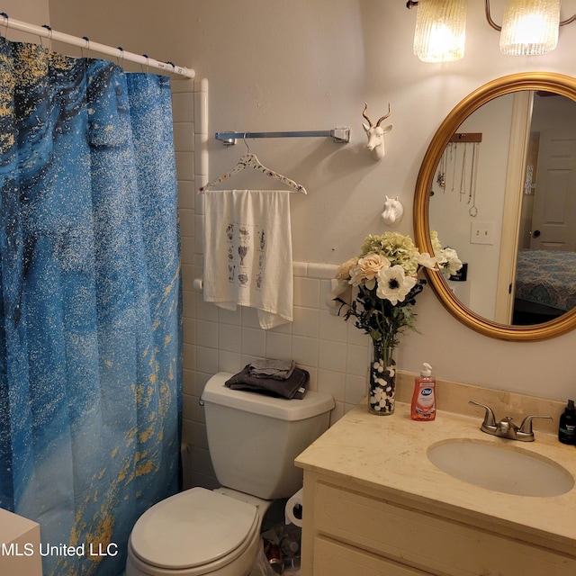 bathroom with vanity, a shower with curtain, a wainscoted wall, tile walls, and toilet