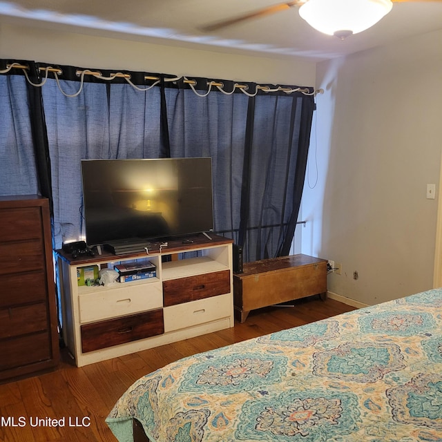 bedroom with wood finished floors and baseboards