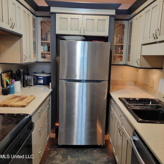 kitchen featuring glass insert cabinets, appliances with stainless steel finishes, and a sink