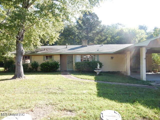 single story home featuring a front lawn