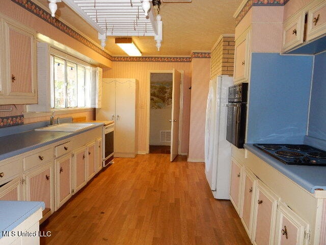 kitchen featuring sink, white appliances, and light hardwood / wood-style floors