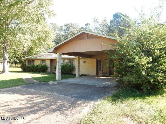 view of front facade with a carport and a front yard