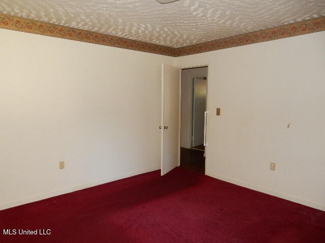 carpeted spare room featuring a textured ceiling