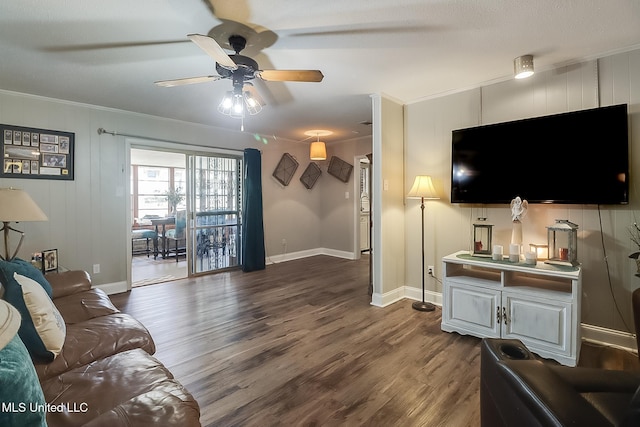 living room featuring baseboards, ceiling fan, ornamental molding, and dark wood-type flooring