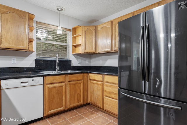 kitchen featuring white dishwasher, sink, pendant lighting, a textured ceiling, and stainless steel refrigerator