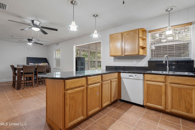 kitchen featuring sink, dishwasher, kitchen peninsula, and decorative light fixtures