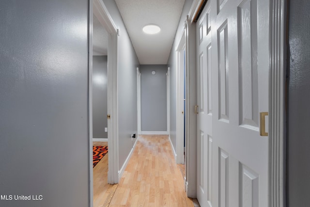 corridor with light hardwood / wood-style floors