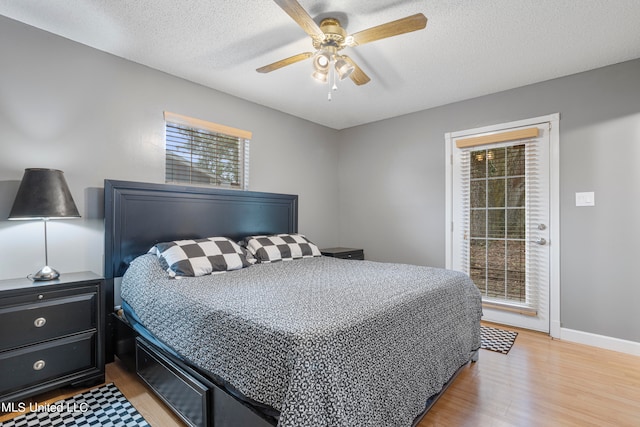 bedroom featuring light hardwood / wood-style flooring, a textured ceiling, and ceiling fan