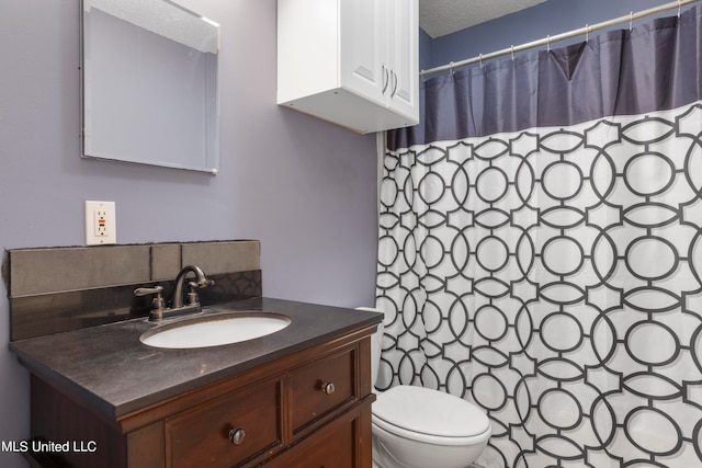 bathroom with vanity, a textured ceiling, and toilet