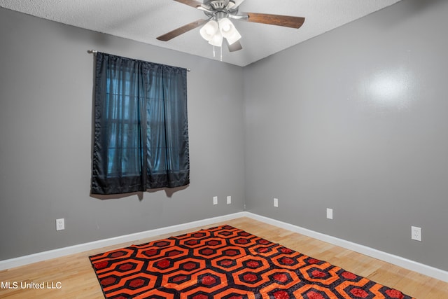 unfurnished room featuring a textured ceiling, wood-type flooring, and ceiling fan