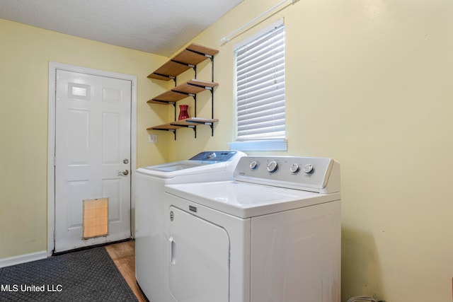 clothes washing area featuring light hardwood / wood-style flooring, independent washer and dryer, and a textured ceiling