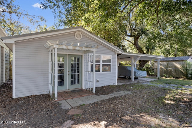 view of outdoor structure with french doors and a carport