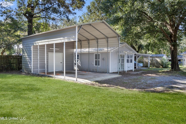 view of outbuilding with a lawn and a carport