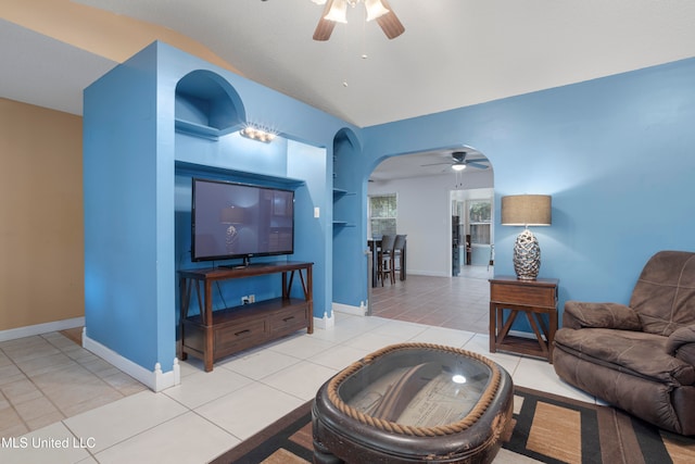 living room featuring lofted ceiling, light tile patterned flooring, and ceiling fan