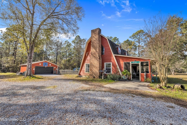 view of property exterior featuring a garage and an outbuilding