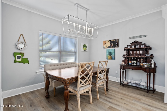 dining area with wood-type flooring and ornamental molding