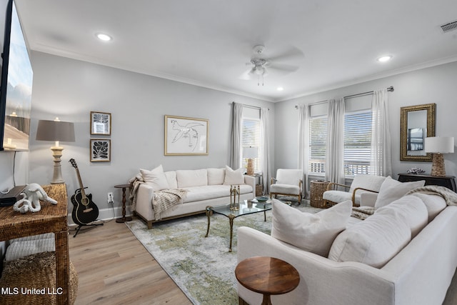 living room featuring light hardwood / wood-style floors, ornamental molding, and ceiling fan