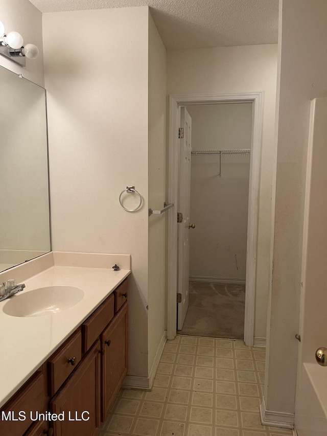 bathroom featuring a textured ceiling and vanity